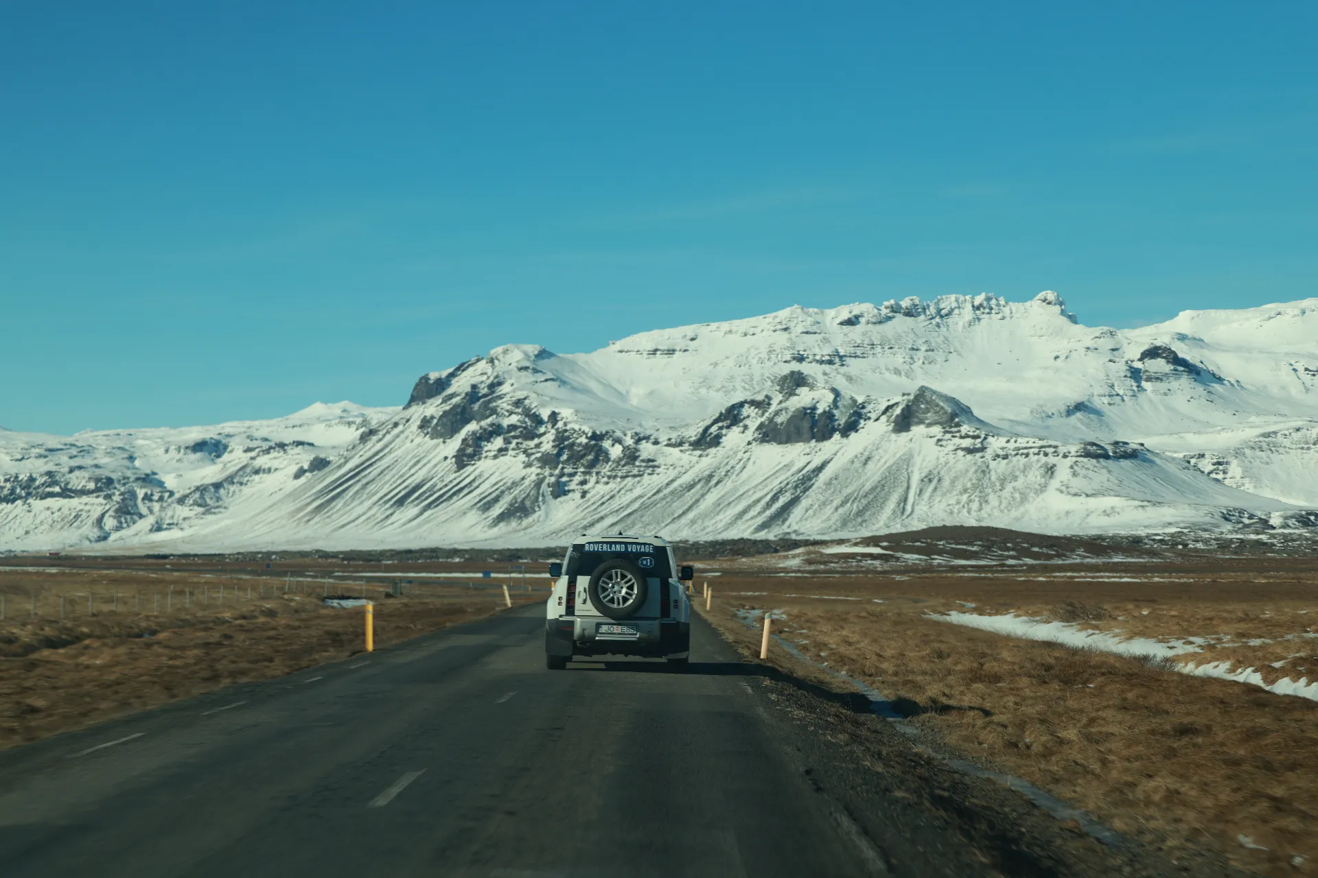 Roverland Voyage Defender on the open Iceland road beneath snow-capped peaks